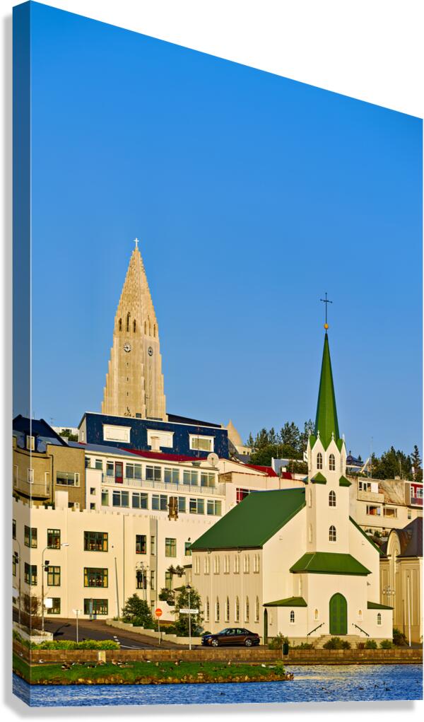 Lutheran free church by lake Tjornin and Halgrimskirkja Canvas Print