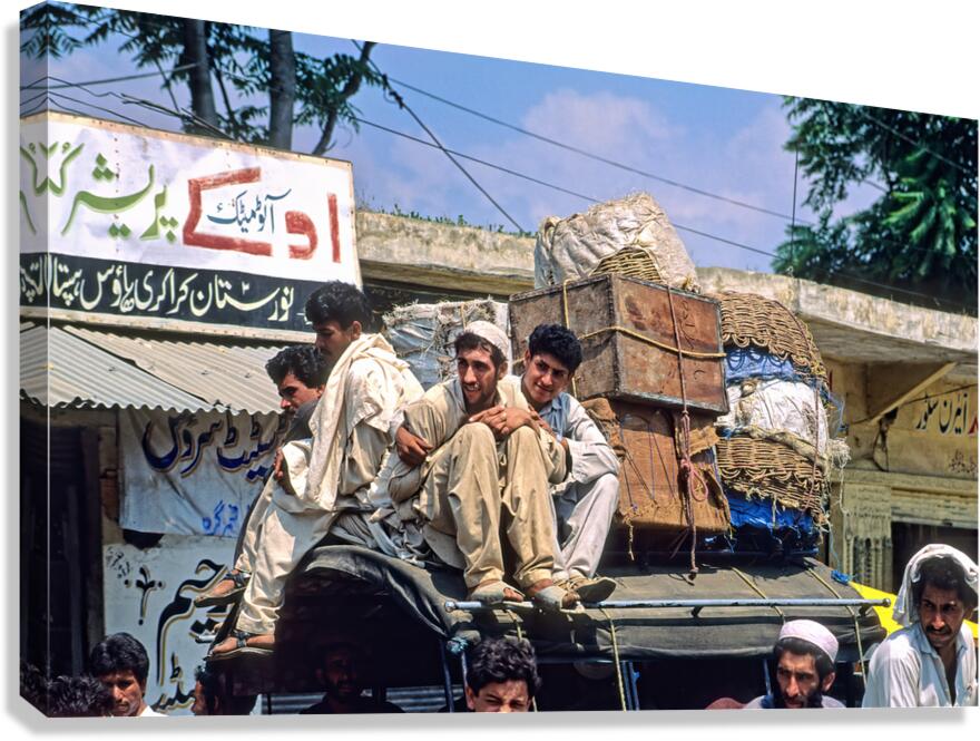 Men travel on top of a vehicle in Peshawar Pakistan Canvas Print