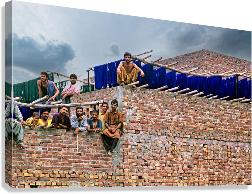 Workers rest during break time at a construction site in Lahore Canvas Print