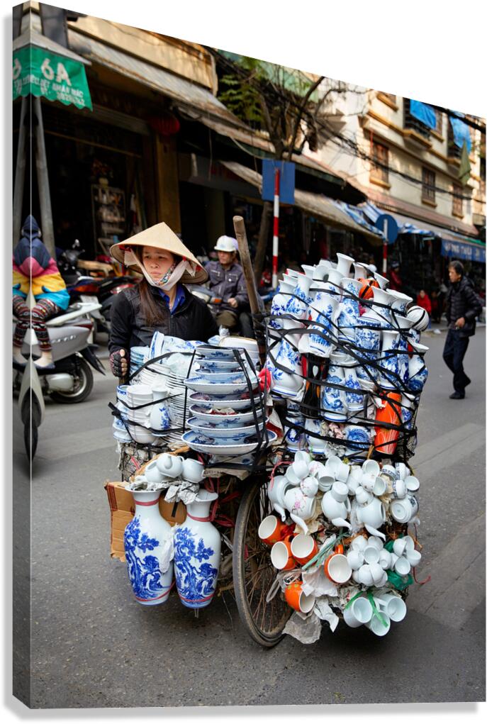Woman transports pottery on a bicycle in Hanoi streets Canvas Print