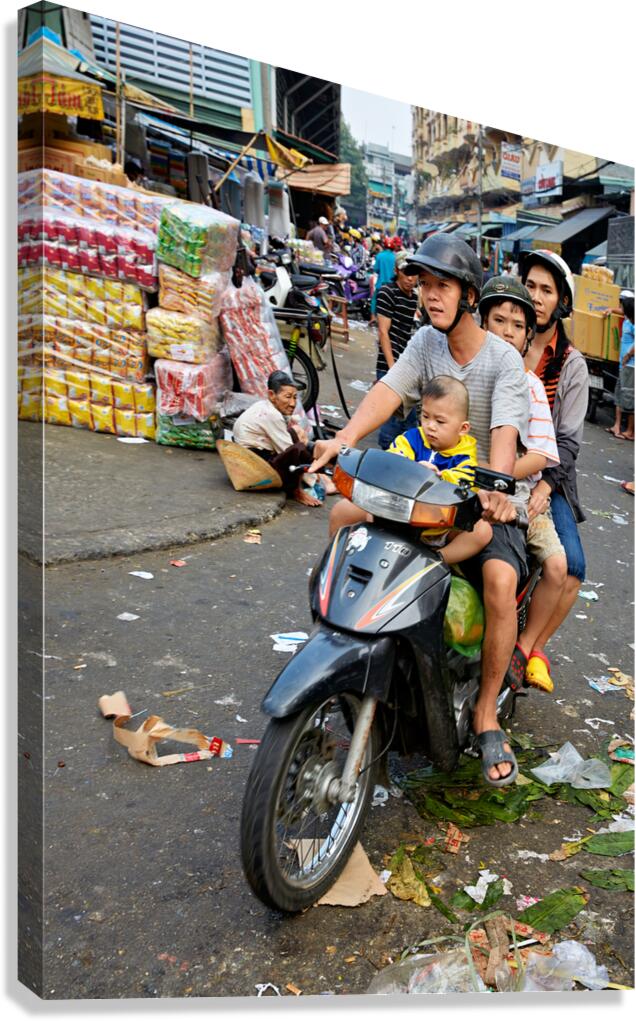 Motorbike family ride through busy Ho Chi Minh street in Vietnam Canvas Print