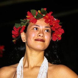 Woman wears red flower crown and shell necklace in Easter Island