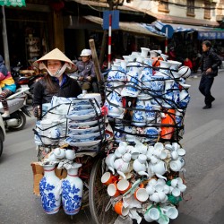 Woman transports pottery on a bicycle in Hanoi streets