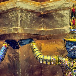 Wat Phra Kaew statues supporting the temple structure in Bangkok