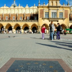 Visitors gather in Krakows main square by day