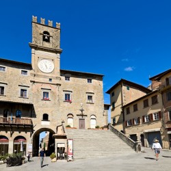 Visitors walk in Piazza della Repubblica near Palazzo del Popolo