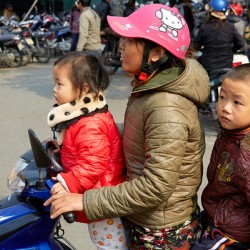 Children riding a motorbike in Hanoi streets