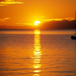 Midnight sun at Longyearbyen in Svalbard with a boat on the water