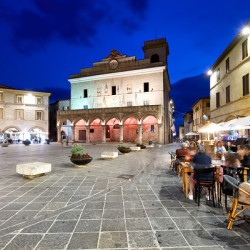 Montefalco Umbria Italy. Piazza del Comune at sunset. People eating out