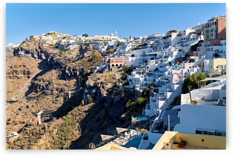 Santorinis white houses cascade down the volcanic cliff. by Marco Brivio