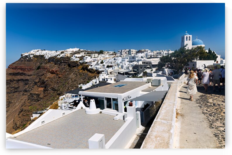 Santorini village on cliff with white buildings and blue domed c by Marco Brivio