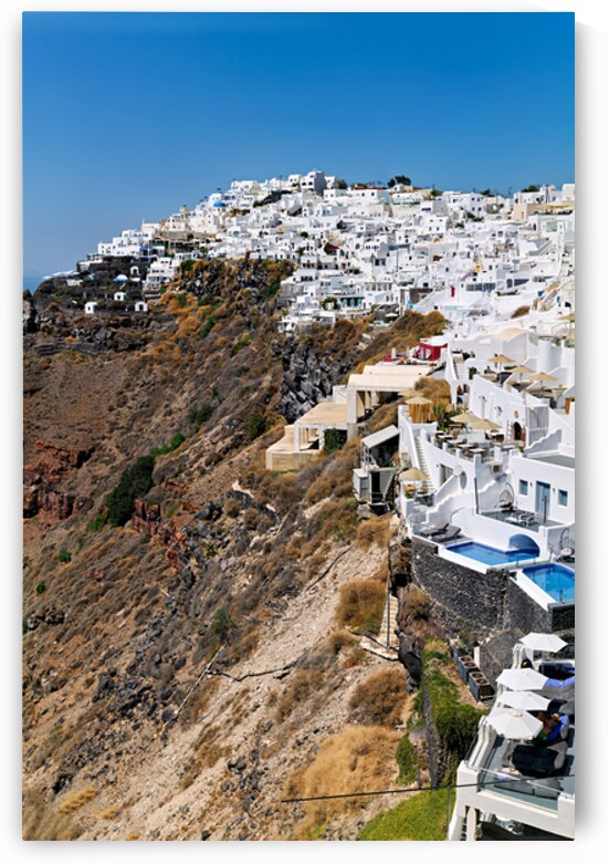 Whitewashed buildings cascade down Santorinis volcanic cliffsid by Marco Brivio