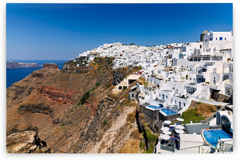 Santorini: White cliffside village blue sea clear sky. by Marco Brivio
