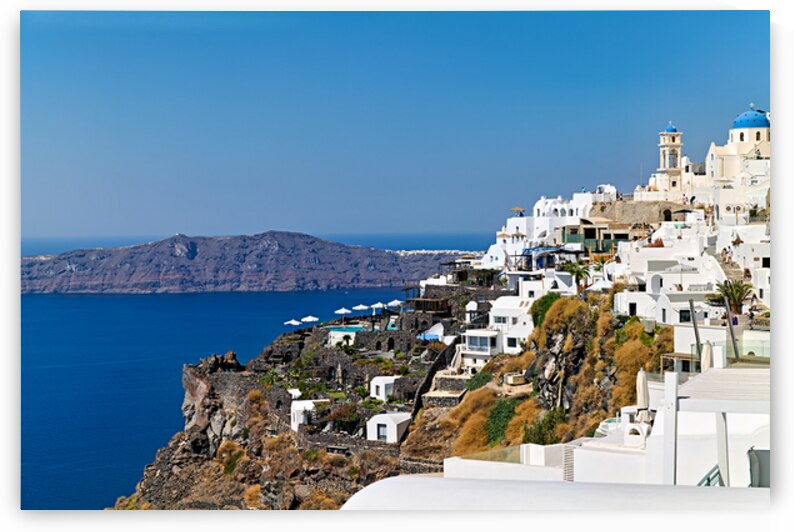 Santorinis white village and blue domes overlooking the Aegean  by Marco Brivio
