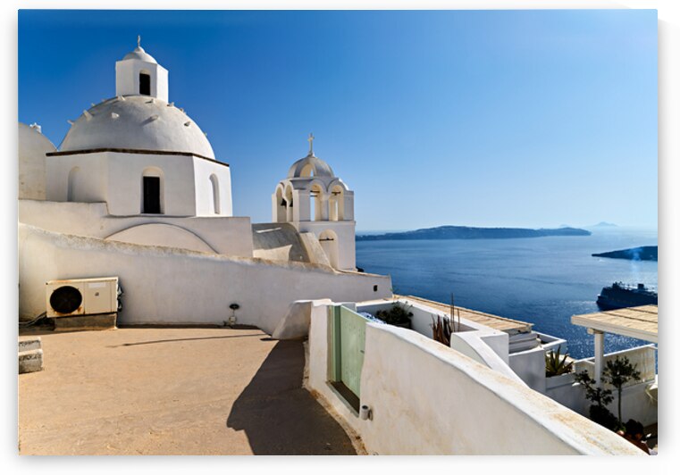 Santorinis iconic white churches overlook the Aegean Sea and ca by Marco Brivio