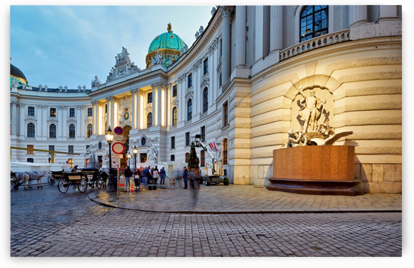 Illuminated Hofburg Palace Vienna with people and horse carria by Marco Brivio