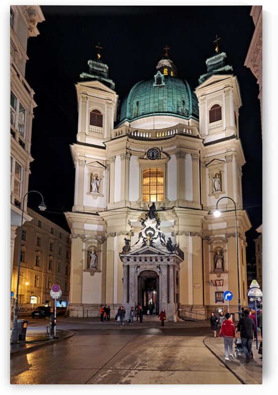 Illuminated baroque church at night with people on a wet street. by Marco Brivio