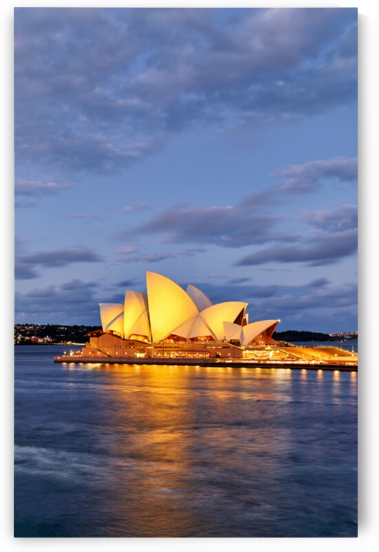 Sydney Opera House illuminated at dusk with harbor reflections. by Marco Brivio