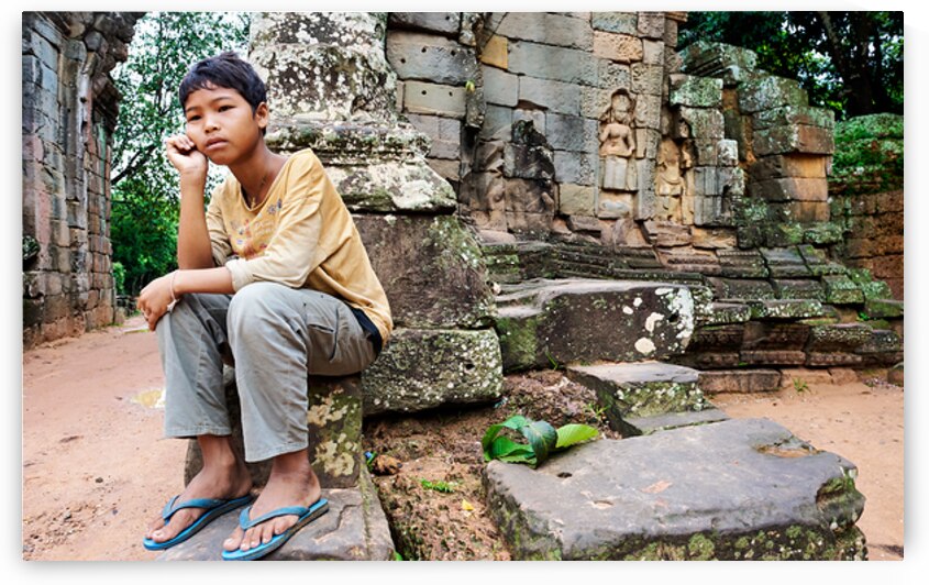Young person sits on ancient temple ruins. by Marco Brivio