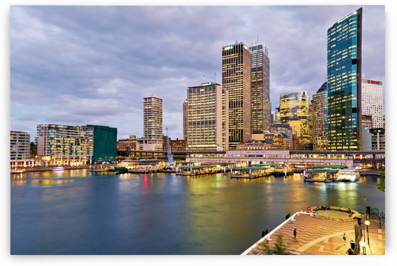 Sydney Harbour at dusk with ferries and city skyline. by Marco Brivio