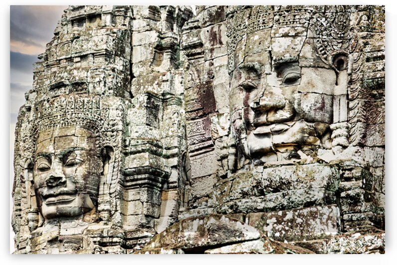 Serene stone faces adorn ancient Cambodian temple. by Marco Brivio