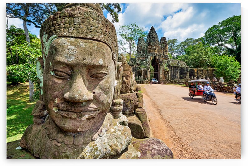 Ancient stone faces and grand temple gate at Angkor Thom. by Marco Brivio