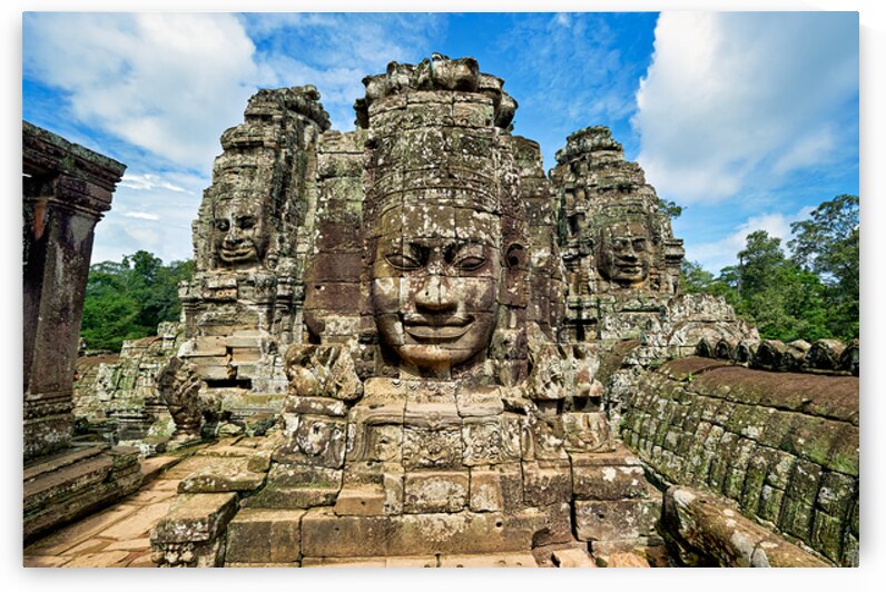 Ancient stone faces on Bayon Temple under a blue sky. by Marco Brivio