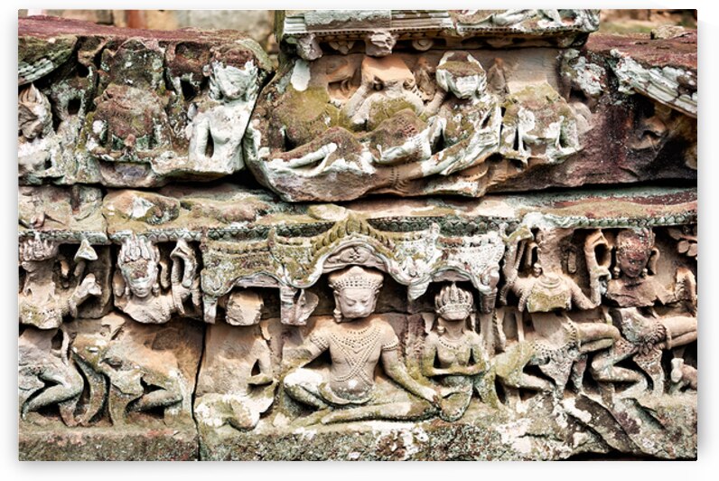 Intricate ancient stone carvings on a moss covered temple. by Marco Brivio
