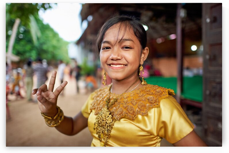 Smiling girl in golden traditional dress makes peace sign. by Marco Brivio
