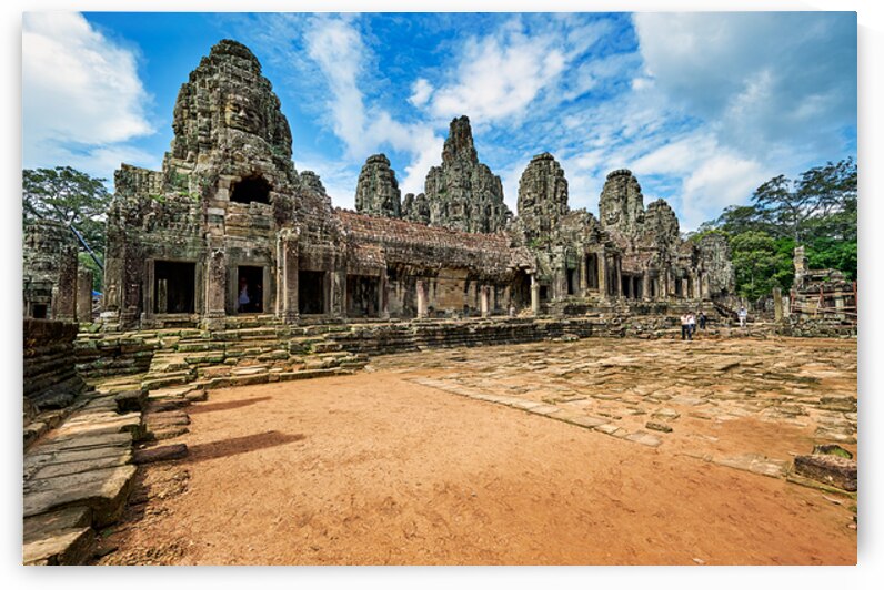 Ancient Bayon temple with stone faces under a blue sky. by Marco Brivio