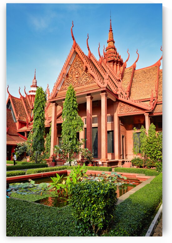 Ornate red Cambodian temple with lush gardens and lily pond. by Marco Brivio