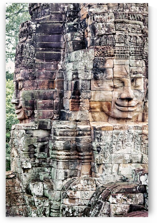 Ancient stone faces carved into a temple wall. by Marco Brivio
