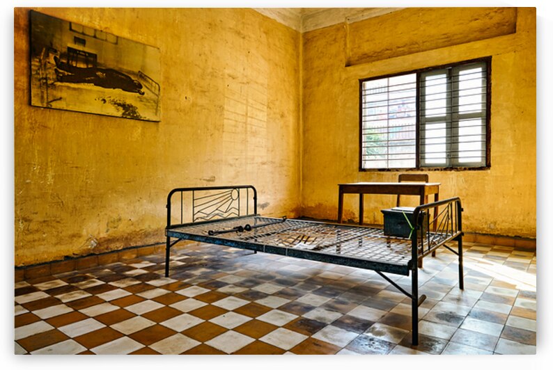 Tuol Sleng Genocide Museum cell with bed and victim photo. by Marco Brivio