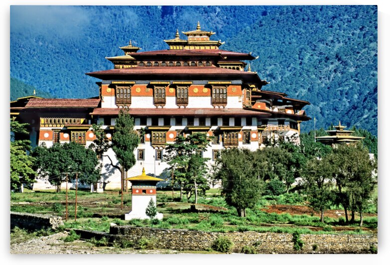 Majestic Bhutanese dzong amidst green mountains and trees. by Marco Brivio