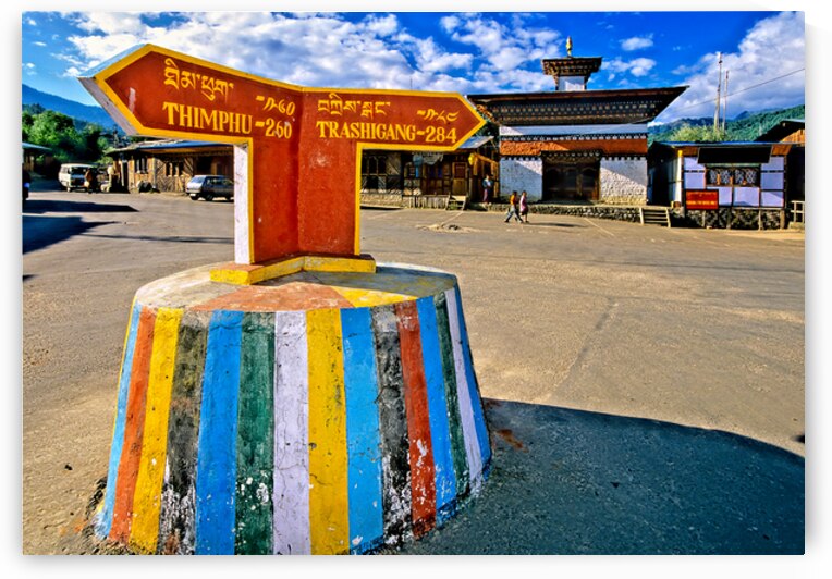 Colorful Bhutanese signpost directs to Thimphu and Trashigang. by Marco Brivio