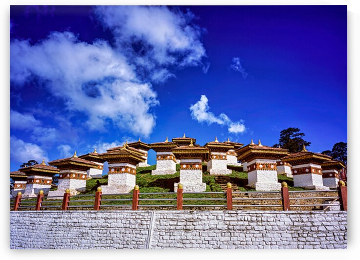 Traditional Bhutanese chortens on a green hill blue sky. by Marco Brivio