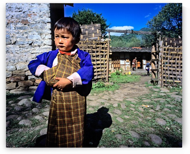 Young child in traditional Bhutanese dress in village. by Marco Brivio