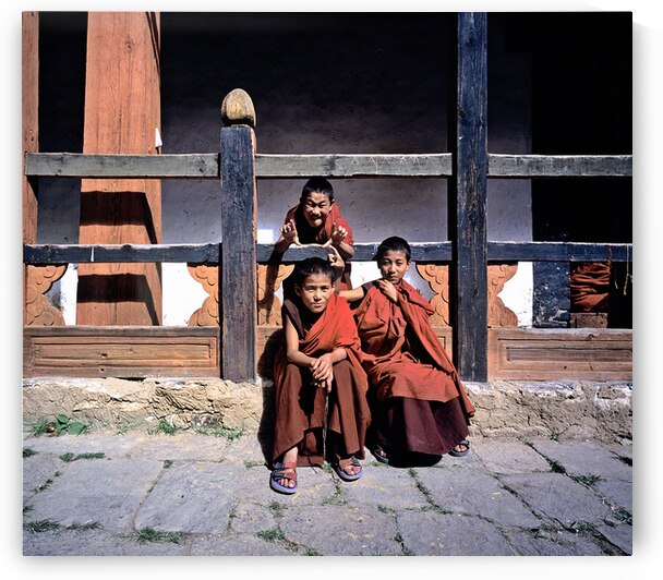 Three young monks playfully pose. by Marco Brivio