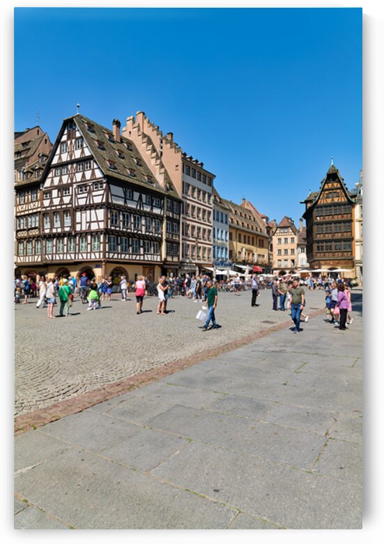 Visitors gather in busy square with colorful houses in Strasbour by Marco Brivio