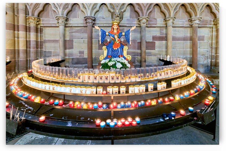 Visitors light votive candles near statue in Strasbourg Cathedra by Marco Brivio