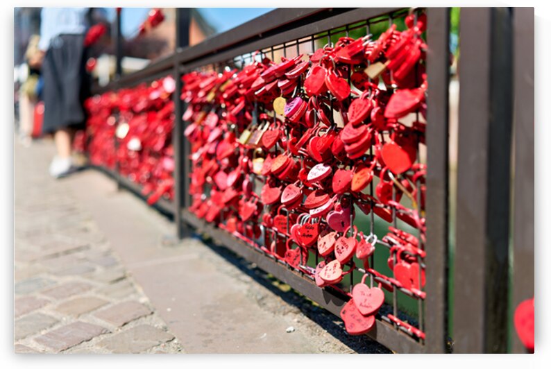 Visitors add red padlocks to a fence in Petite Venise Colmar by Marco Brivio