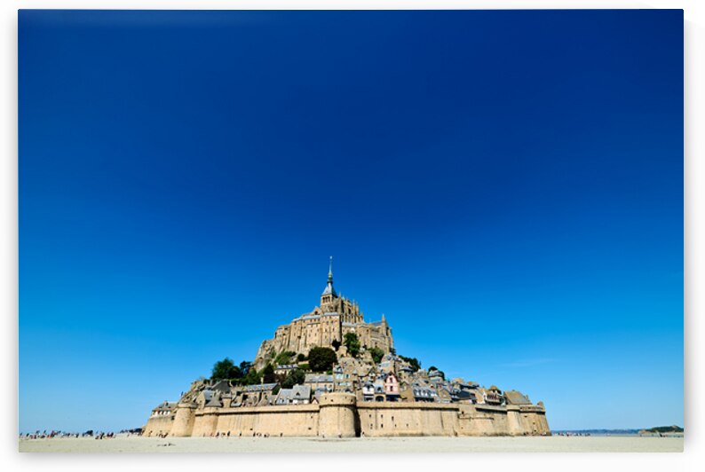 Mont Saint Michel rises above the ground during low tide in Norm by Marco Brivio