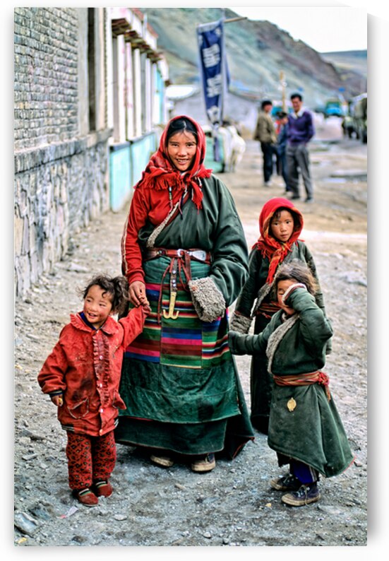 Smiling woman and children in traditional attire in Tibet by Marco Brivio