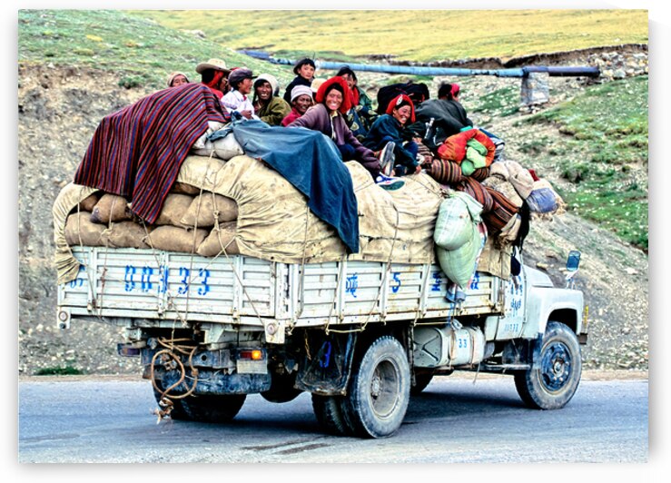 Joyful people riding on a loaded truck in Tibet by Marco Brivio