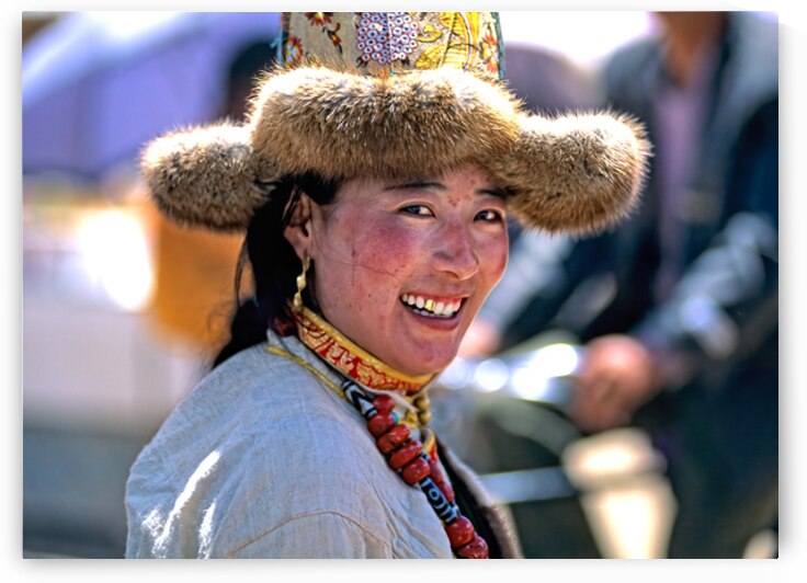 Smiling woman in fur hat and beaded necklace in Tibet market by Marco Brivio