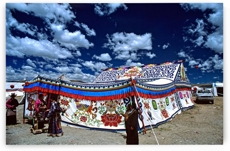 Colorful Tibetan tent with people under a cloudy sky in Tibet by Marco Brivio