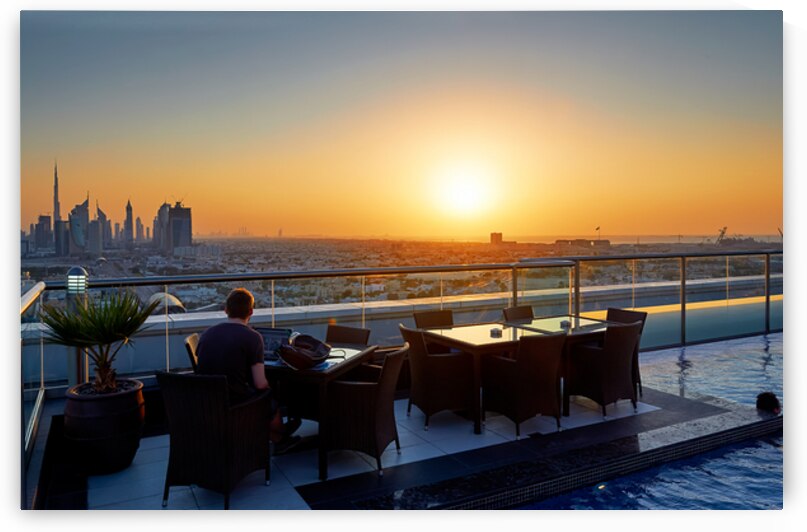 Working on a rooftop with Dubai skyline view at sunset by Marco Brivio