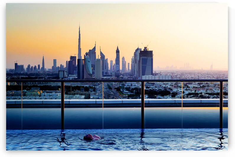 Swimming in infinity pool overlooking Dubai skyline at sunset by Marco Brivio