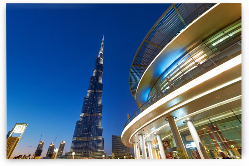 Burj Khalifa at night with modern buildings in Dubai skyline by Marco Brivio