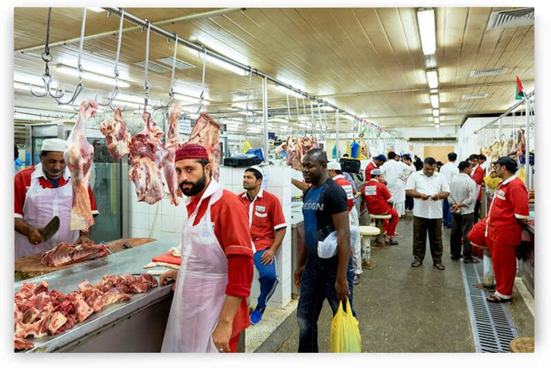 Butchers work at a busy meat market in Dubai UAE preparing fresh by Marco Brivio
